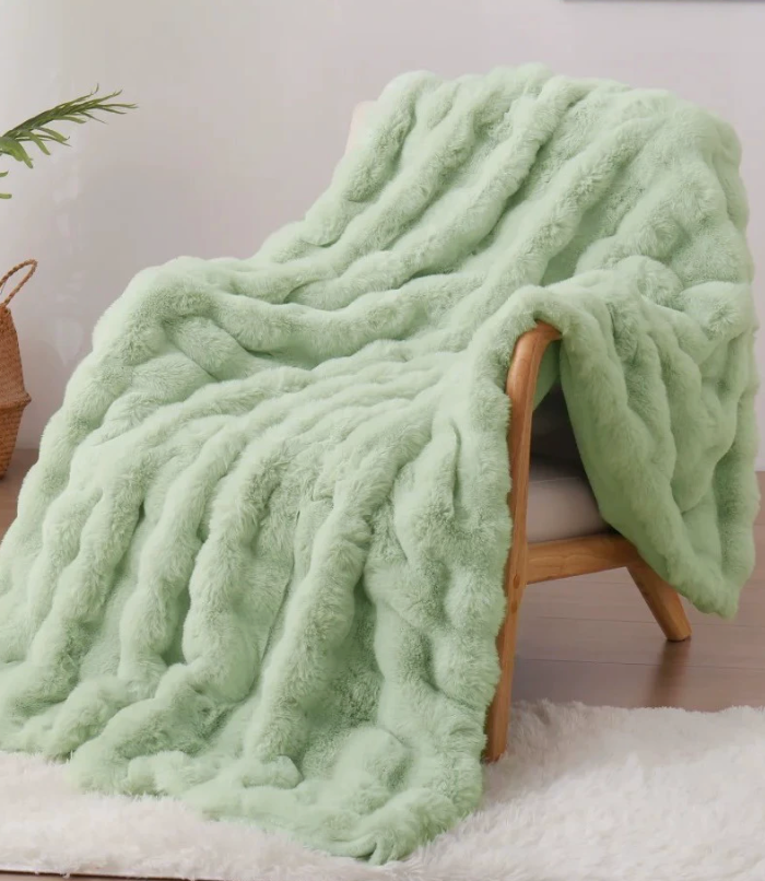 Mint blanket draped over a wooden armchair