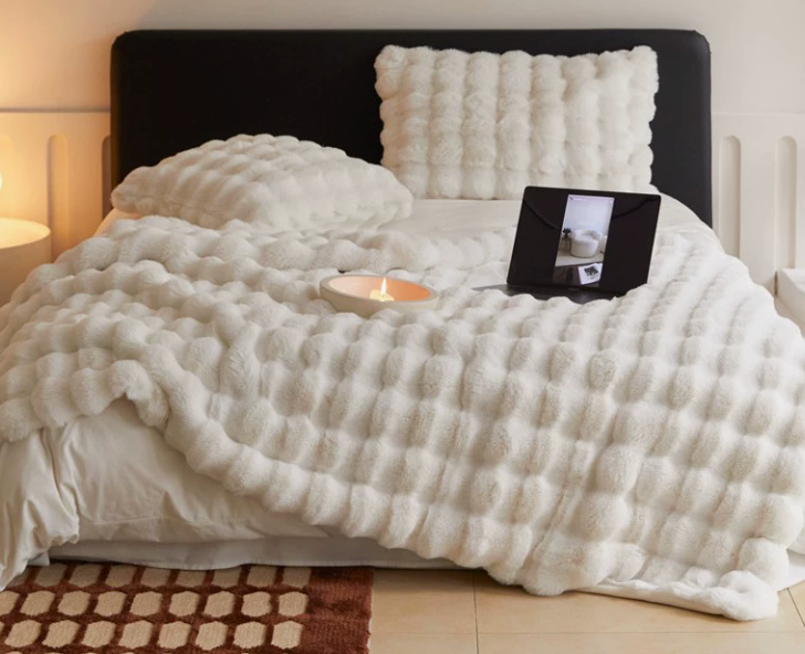 White textured blanket spread across a bed